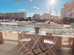 a balcony with a table and chairs and a harbor at Magnifique T2 au calme avec une superbe vue sur le port in Canet-en-Roussillon