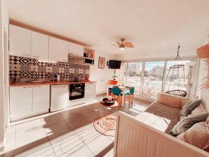 a kitchen and living room with a couch and a table at Magnifique T2 au calme avec une superbe vue sur le port in Canet-en-Roussillon