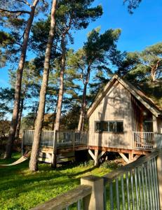 a house with a porch and a fence and trees at Toad Hall in Grimston