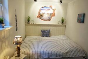 Un dormitorio con una cama y una lámpara sobre una mesa. en Meer-Zeit - UG - Seegras, en Kappeln