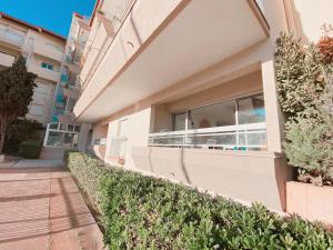 a building with a balcony with plants and a sidewalk at Magnifique T2 au calme avec une superbe vue sur le port in Canet-en-Roussillon