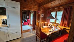 a kitchen and dining room with a table in a cabin at Ferienhaus Neckar 55 in Hayingen