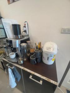 un bancone con macchinetta del caffè e tazze sopra di C-Hill Camp&Resort a Mae Rim