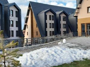 un grupo de edificios con nieve delante de ellos en Apartman Nina Divcinova, en Divčibare