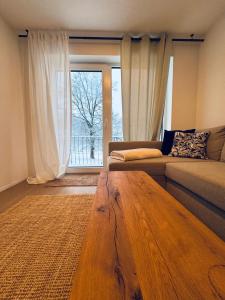 ein Wohnzimmer mit einem Sofa und einem Holztisch in der Unterkunft FeWo Anders - Neubau mit Balkon im Bergischen Land in Reichshof 