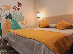 una camera con 2 letti con cuscini arancioni di Refugio del Inca a Salta