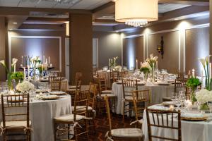 a banquet room with tables and chairs with white table linens at The Hotel Zamora in St. Pete Beach +37 photos