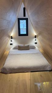 a bedroom with a large bed with a window at Bjelašnica Frame in Bjelašnica