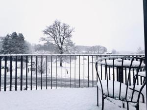 ein mit Schnee bedeckter Zaun neben einer Bank in der Unterkunft FeWo Anders - Neubau mit Balkon im Bergischen Land in Reichshof 
