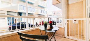 a balcony with a table and chairs in a building at Apto Familiar en Alicante, 4 Pax, 3 Camas, 2 Baños in Elche