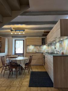 a kitchen with a table and a dining room at Gîtes Sous Les Loges - Mountain Apartments Lélex in Lélex