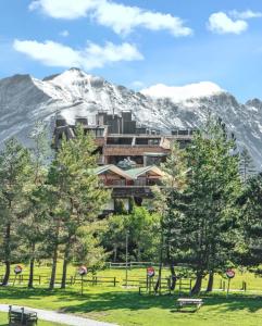 a building in front of a snow covered mountain at Studio chaleureux à Uvernet-Fours, 25m² avec vue montagne in Uvernet-Fours