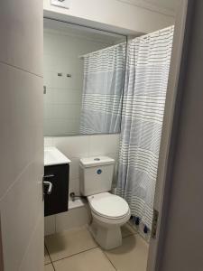 a bathroom with a white toilet and a sink at Departamento frente a la playa in Arica +19 photos
