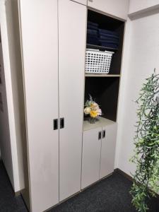 a closet with white cabinets and flowers in it at JKhouse5 in Fukuoka