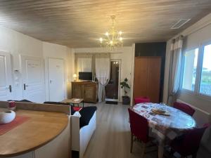 salon ze stołem i żyrandolem w obiekcie Ravissant T2, Cl 3 étoiles, 3 pers et 1 enf , 3 lits, parking et patio w mieście Saint-Sever
