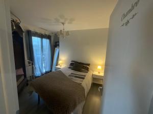 sypialnia z łóżkiem i oknem z 2 lampami w obiekcie Ravissant T2, Cl 3 étoiles, 3 pers et 1 enf , 3 lits, parking et patio w mieście Saint-Sever