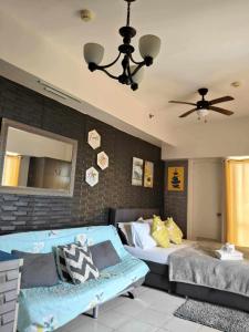 ein Schlafzimmer mit einem Bett, einer Couch und einem Spiegel in der Unterkunft Tagaytay Cityland Taal Lake View with balcony by SAB in Tagaytay + 13 Fotos