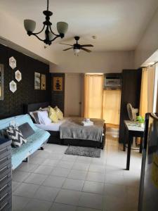 ein Schlafzimmer mit einem Bett und einem Deckenventilator in der Unterkunft Tagaytay Cityland Taal Lake View with balcony by SAB in Tagaytay