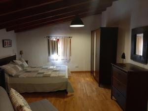 Un dormitorio con una cama y una cómoda en una habitación. en Lobetania, en Moscardón