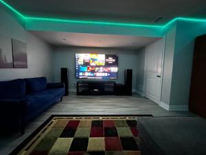 un soggiorno con divano e TV a schermo piatto di Ravine Retreat - 3RM Suite, 2BD, 1 WR, Pool, Sauna a Whitby