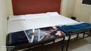 a bed with two blankets on top of it at Shree home stay in Ujjain
