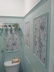 a bathroom with a toilet and two pictures on the wall at The Garway in Torquay