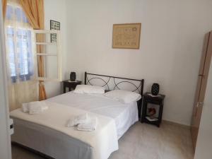 a bedroom with a white bed with two towels on it at Nektarios Village House in Neápolis
