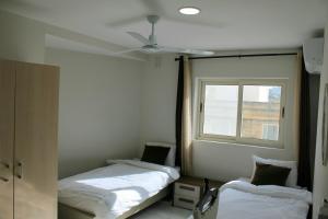 two beds in a room with a window at Twin Room with Private Bathroom - Room 1 in Tal-Għoqod