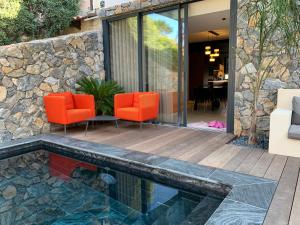 a patio with orange chairs and a swimming pool at Le paradis sur mer 2 in Six-Fours-les-Plages