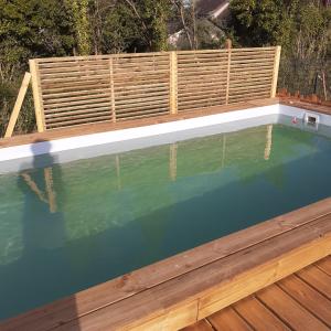 a swimming pool with a wooden fence around it at TY FAROMA - SUPERBE MAISON DE VACANCES in Sarzeau