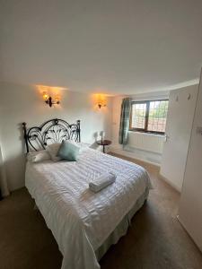 - une chambre avec un grand lit et un couvre-lit blanc dans l'établissement The Pumpkin Barn, à East Farleigh