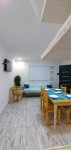 a living room with a table and chairs and a couch at Dpto nuevo frente al Rio in Necochea