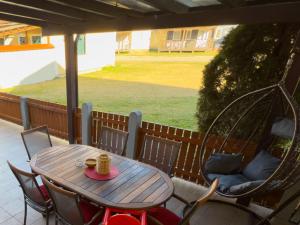 a wooden table and chairs on a porch with a cup of coffee at La Hiška Čatež with Tickets - each guest gets 2 entries per day in Čatež ob Savi