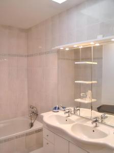 a bathroom with two sinks and a tub and a mirror at Maison familiale paisible proche de Braslou + jardin spacieux in Braslou +16 photos