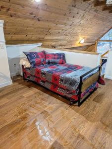 a bed in a room with a wooden ceiling at A New A-Frame of Mind Cabin in Birnamwood