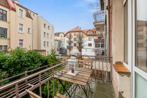 un balcone con panca in legno su una strada della città di Sopot Host a Sopot