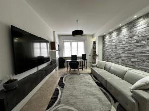 a living room with a couch and a large flat screen tv at Amazing Varese Central Apartment in Varese