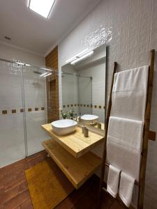 a bathroom with two sinks and a glass shower at Monte da Caniveta - Casa dos Compadres in São Luis +32 photos