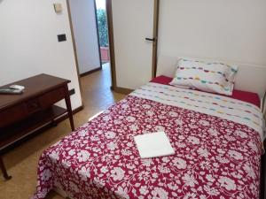 a bedroom with a bed with a red and white blanket at Dimora ANETT B&B HOUSE in Codevigo