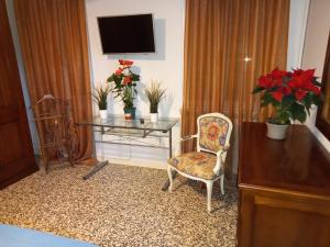 a room with a table and a chair and a television at Dimora ANETT B&B HOUSE in Codevigo