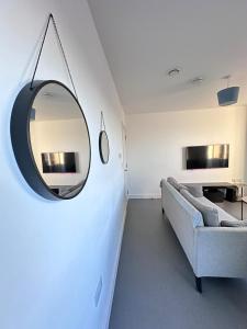 a living room with a mirror and a couch at Beautiful 1 Bd Top floor Terraced Apartment in Barking