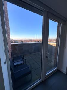 an open glass door to a balcony with a view at Beautiful 1 Bd Top floor Terraced Apartment in Barking