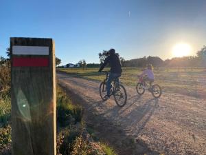 a man and a child riding bikes down a dirt road at Monte da Caniveta - Casa do Avô in São Luis