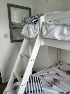 a white bunk bed with a mirror in a room at Chalet 75 in Mundesley