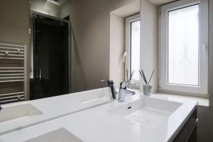Un baño blanco con lavabo y espejo. en Appartement rénové idéalement situe dans le centre piéton des Sables d'Olonne, en Les Sables-dʼOlonne 16 fotos más