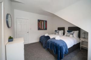 a bedroom with two beds with blue sheets at 2-Bed Apartment Sleeps 5 - Near Royal Alexandria Hospital - Free Parking & Longs Stays Available in Paisley