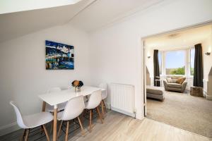 a dining room with a white table and chairs at 2-Bed Apartment Sleeps 5 - Near Royal Alexandria Hospital - Free Parking & Longs Stays Available in Paisley