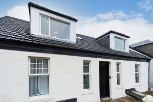 a white house with a black roof at 2-Bed Apartment Sleeps 5 - Near Royal Alexandria Hospital - Free Parking & Longs Stays Available in Paisley