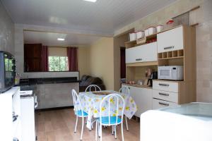 a kitchen with a table and chairs in a kitchen at Sitio encantador e tranquilo com churrasq e Wi-fi in Marechal Floriano