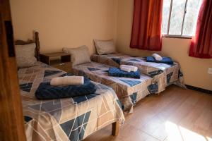 three beds in a room with red curtains at Sitio encantador e tranquilo com churrasq e Wi-fi in Marechal Floriano